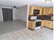 Eat-in kitchen featuring wood cabinetry, black countertops and black and tan backsplash and adjoining living area at 3716 Mistwood Dr, Tampa, FL 33619