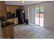 Eat-in kitchen featuring wood cabinetry, black countertops, and sliding glass door to patio at 3716 Mistwood Dr, Tampa, FL 33619