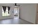 Living room featuring gray vinyl flooring, white walls, black curtains and a door with security screen at 3716 Mistwood Dr, Tampa, FL 33619