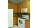 Efficient kitchen featuring oak cabinets, tile backsplash, white appliances, and durable countertops at 2011 N 61St St, Tampa, FL 33619