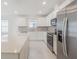 A modern kitchen featuring white cabinets, stainless steel appliances, and a large island at 9661 Summers Cay Cir, Thonotosassa, FL 33592