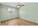 Bright bedroom with wood flooring, light green walls, ceiling fan and window with garden view at 414 Mahogany Dr, Seffner, FL 33584