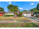 Well-maintained one-story home featuring a green lawn, mature trees, and an attached garage at 414 Mahogany Dr, Seffner, FL 33584
