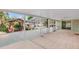 Enclosed lanai with tile flooring, a ceiling fan, and views of the surrounding greenery and gazebo at 414 Mahogany Dr, Seffner, FL 33584