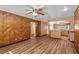 Spacious living room featuring wood floors, wood paneled walls and an open layout leading to kitchen at 414 Mahogany Dr, Seffner, FL 33584
