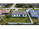 An aerial view captures a home nestled among neatly fenced yards and manicured green lawns at 20296 Rutherford Ave, Port Charlotte, FL 33952
