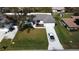 Aerial view of a single-story home with a green lawn, driveway, and well-kept landscaping at 20296 Rutherford Ave, Port Charlotte, FL 33952