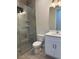 Well-lit bathroom featuring a marble-look glass shower, toilet and vanity with modern fixtures at 20296 Rutherford Ave, Port Charlotte, FL 33952