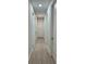 Hallway with wood-look floors, white trim and doors creates a simple and clean design at 20296 Rutherford Ave, Port Charlotte, FL 33952