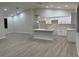 Open-concept kitchen with white cabinetry, quartz countertops, wood-look tile flooring, and pendant lighting at 20296 Rutherford Ave, Port Charlotte, FL 33952
