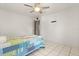 Bright bedroom with a ceiling fan, tile floors, and a blue patchwork quilt bedspread at 5744 Calais N Blvd # 4, St Petersburg, FL 33714