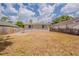 The backyard has a neutral-colored home exterior, a wood fence, and a grassy area under a blue sky at 4010 Emerson S Ave, St Petersburg, FL 33711