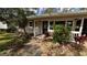 Charming single-story home featuring a cozy front porch and lush tropical landscaping at 3141 Irving St, Sarasota, FL 34237