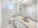 Bathroom features a white vanity with marble countertop, framed mirror and updated fixtures at 9420 Ripley Rd, Thonotosassa, FL 33592