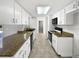 Galley kitchen with granite countertops, updated appliances, and ample cabinet storage at 9420 Ripley Rd, Thonotosassa, FL 33592