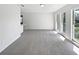 Bright living room with large windows, neutral carpet, and fresh paint provides a blank canvas at 9420 Ripley Rd, Thonotosassa, FL 33592
