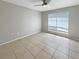 A bright bedroom with neutral walls, tile flooring, and a window for natural light at 9481 Highland Oak Dr # 609, Tampa, FL 33647