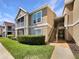 Exterior view of tan condo building with stairs leading to upper units and green grass at 9481 Highland Oak Dr # 609, Tampa, FL 33647