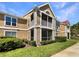 A two-story condo unit with tan stucco, green lawn, and screened-in porch at 9481 Highland Oak Dr # 609, Tampa, FL 33647