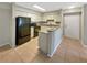 Galley kitchen with granite countertops, white cabinets, and black appliances at 9481 Highland Oak Dr # 609, Tampa, FL 33647