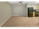 An empty, open concept living room with tile floors that leads into the kitchen at 9481 Highland Oak Dr # 609, Tampa, FL 33647