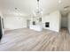 Open-concept kitchen and living area featuring an island and modern lighting fixtures over wood flooring at 15561 Aldama Cir, Port Charlotte, FL 33981