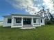 A modern home with a white exterior, a covered porch, and a well-manicured lawn offers a serene and inviting outdoor space at 15561 Aldama Cir, Port Charlotte, FL 33981
