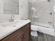 Bathroom featuring wood vanity with light countertop, tile backsplash, and shower over tub at 837 Dolphin Nw Ave, Port Charlotte, FL 33948