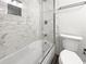 Updated bathroom featuring a tiled shower over a tub with glass door and modern fixtures at 837 Dolphin Nw Ave, Port Charlotte, FL 33948
