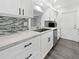 Modern kitchen featuring white cabinets, stainless steel appliances, and stylish backsplash at 837 Dolphin Nw Ave, Port Charlotte, FL 33948