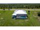 Aerial view of a light blue house with an in-ground pool and screened-in lanai on a sprawling green lawn at 261 Rotonda S Blvd, Rotonda West, FL 33947