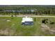 Aerial view of a light blue house with an in-ground pool and screened-in lanai backed by pond and mature trees at 261 Rotonda S Blvd, Rotonda West, FL 33947
