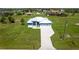 An aerial view of a blue single-story home with a three-car garage and well-manicured lawn at 261 Rotonda S Blvd, Rotonda West, FL 33947