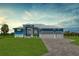 Beautiful blue single-story home featuring a well-manicured lawn and a three-car garage at 261 Rotonda S Blvd, Rotonda West, FL 33947