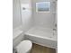 Clean white bathroom featuring a tub and shower combo with sleek fixtures at 8253 Penwood Dr, Port Richey, FL 34668