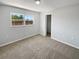 Bright bedroom featuring a window, closet, neutral carpet and light gray walls at 8253 Penwood Dr, Port Richey, FL 34668