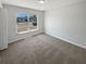 This bedroom features plush carpeting and plenty of sunlight from the large window at 8253 Penwood Dr, Port Richey, FL 34668