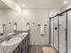 Modern bathroom with double sinks, granite countertops, and a glass enclosed shower with matte black trim at 17737 Canopy Pl, Bradenton, FL 34211