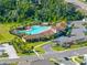 Aerial shot of the community pool with palm trees, clubhouse and parking lot at 17737 Canopy Pl, Bradenton, FL 34211