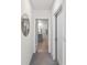 Hallway leading to bathroom, featuring neutral walls, new carpet, and storage closet at 17737 Canopy Pl, Bradenton, FL 34211