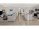 Inviting living room with an open floor plan, featuring tile flooring, neutral walls, and a large sofa at 17737 Canopy Pl, Bradenton, FL 34211