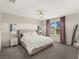 Comfortable bedroom featuring a plush bed, elegant lighting, and a view of the outdoors through a large window at 17737 Canopy Pl, Bradenton, FL 34211