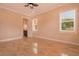 Bright bedroom with a bathroom view featuring neutral walls, tile flooring, and natural light at 2202 Sparkman Rd, Plant City, FL 33566