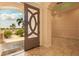 Inviting entryway with a decorative glass door, marble flooring, and a glimpse of the lush front yard at 2202 Sparkman Rd, Plant City, FL 33566