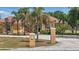 Lovely orange stucco home boasting a red tile roof, lush tropical landscaping, and an expansive circular driveway at 2202 Sparkman Rd, Plant City, FL 33566
