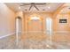 Open concept living room with unique arches, neutral color palette, and shiny tile floors at 2202 Sparkman Rd, Plant City, FL 33566