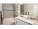 Bright bathroom featuring a double vanity with granite countertop and a tub with tiled walls at 25416 Jubal St, Punta Gorda, FL 33955