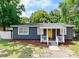 Charming single-story home with a yellow front door and manicured landscaping at 5004 E Seneca Ave, Tampa, FL 33617