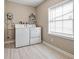 Laundry room with washer, dryer, and window for natural light at 5004 E Seneca Ave, Tampa, FL 33617