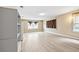 Open living room featuring wood-look floors, large windows and shelving units for ample storage space at 5004 E Seneca Ave, Tampa, FL 33617